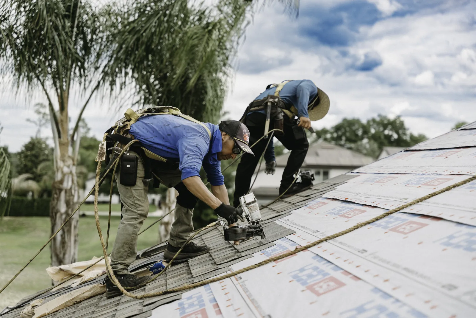 Crew installing single-ply membrane at a commercial roof edge