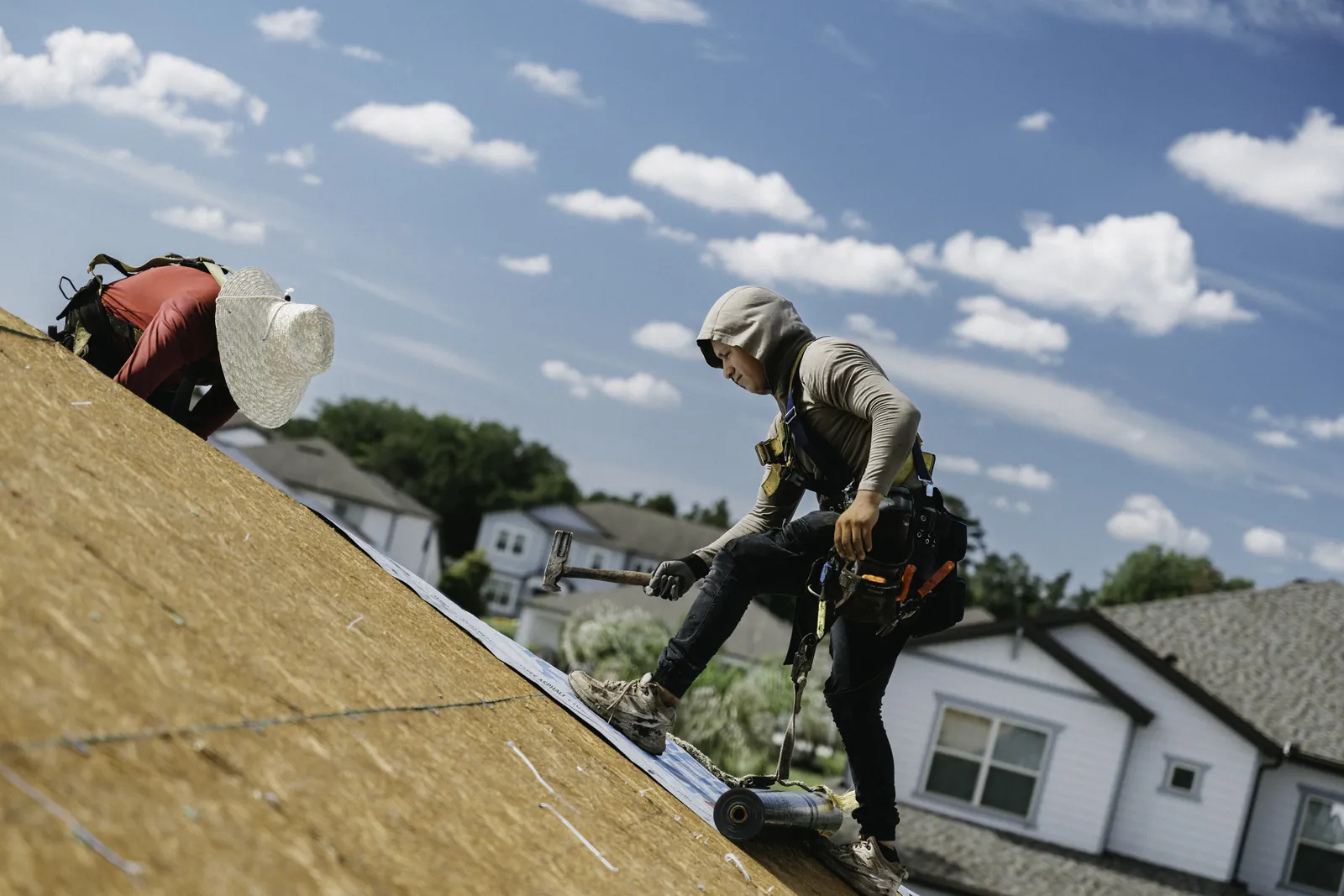 Roofing crew preparing a roof deck for installation