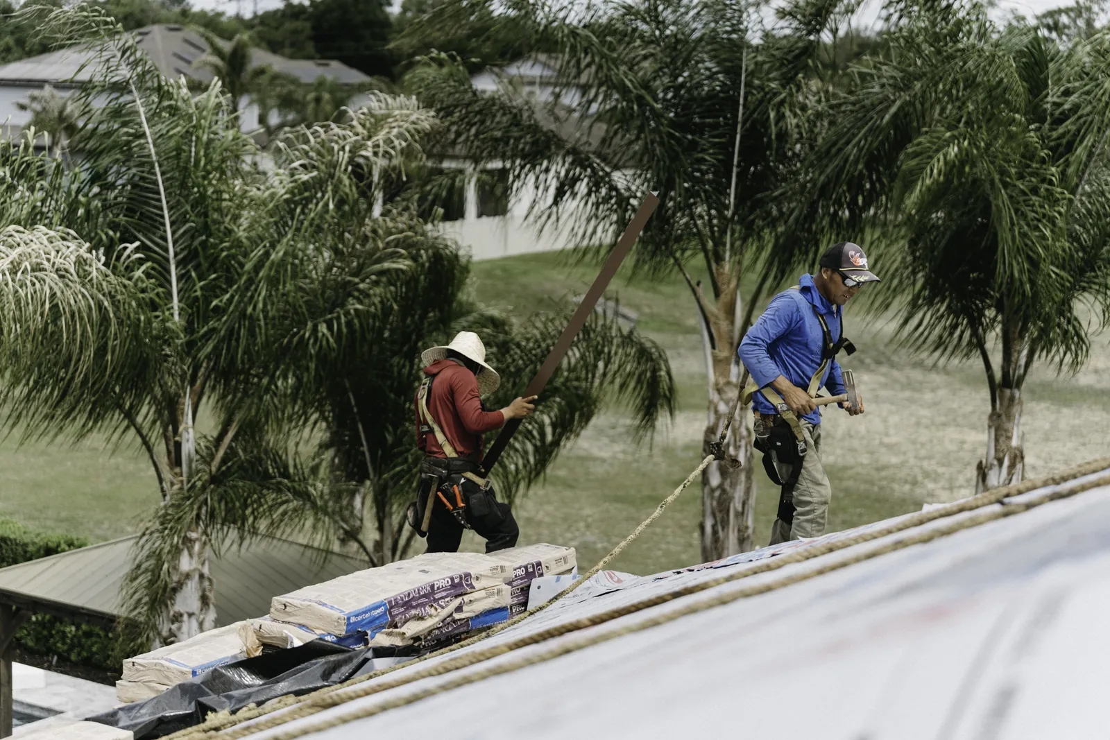 Roofing crew working on the edge of a broad roof