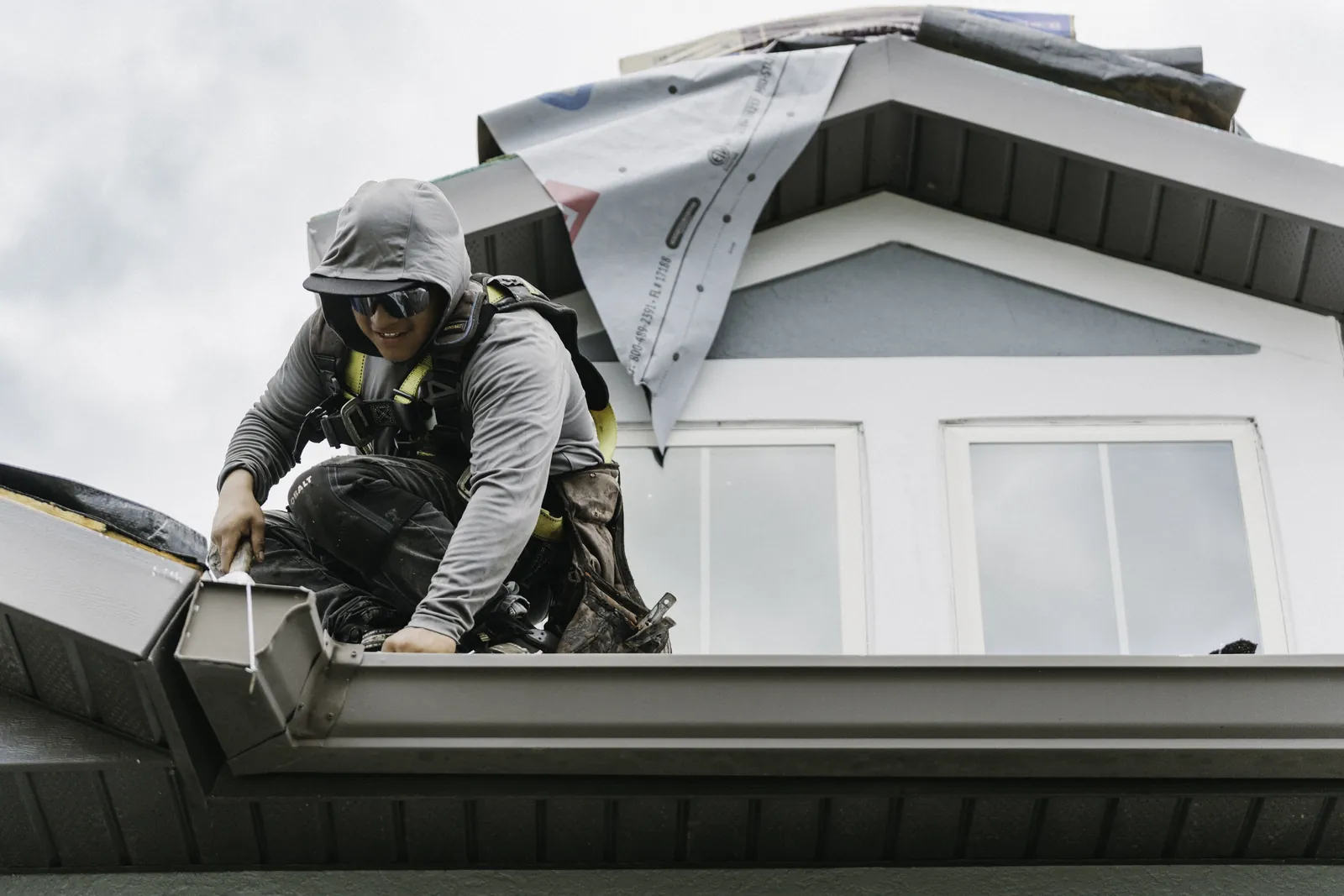 Roofer installing flashing at a roof transition