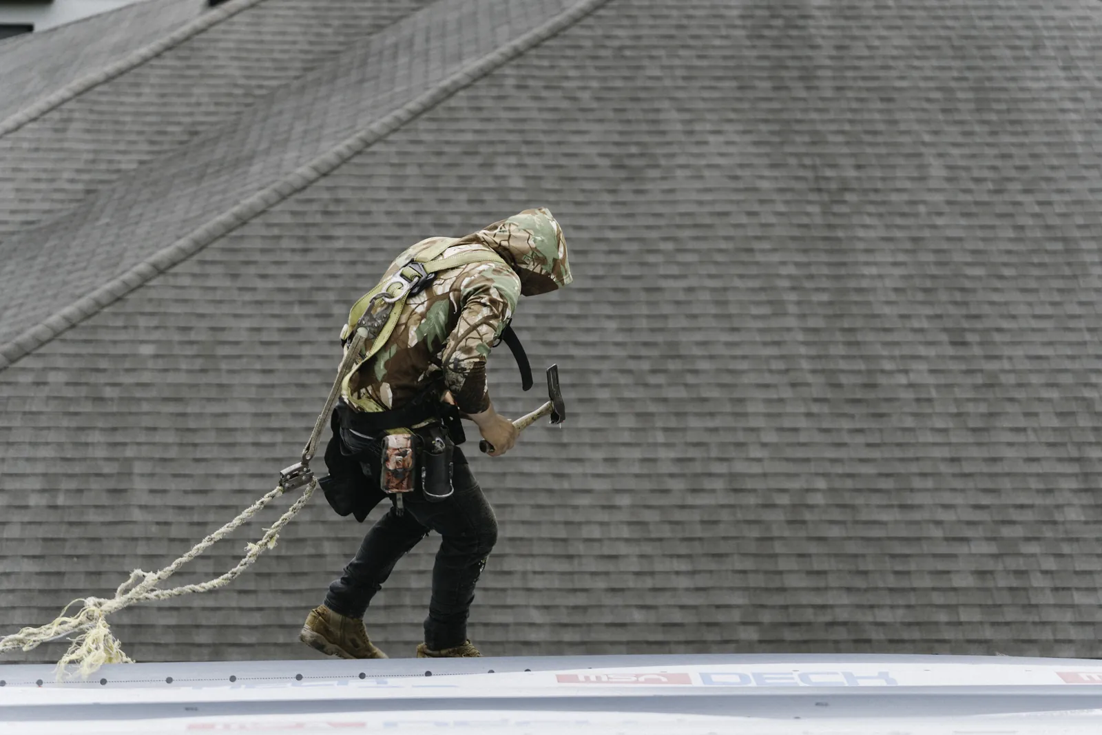 Roofer above a newly finished shingle roof