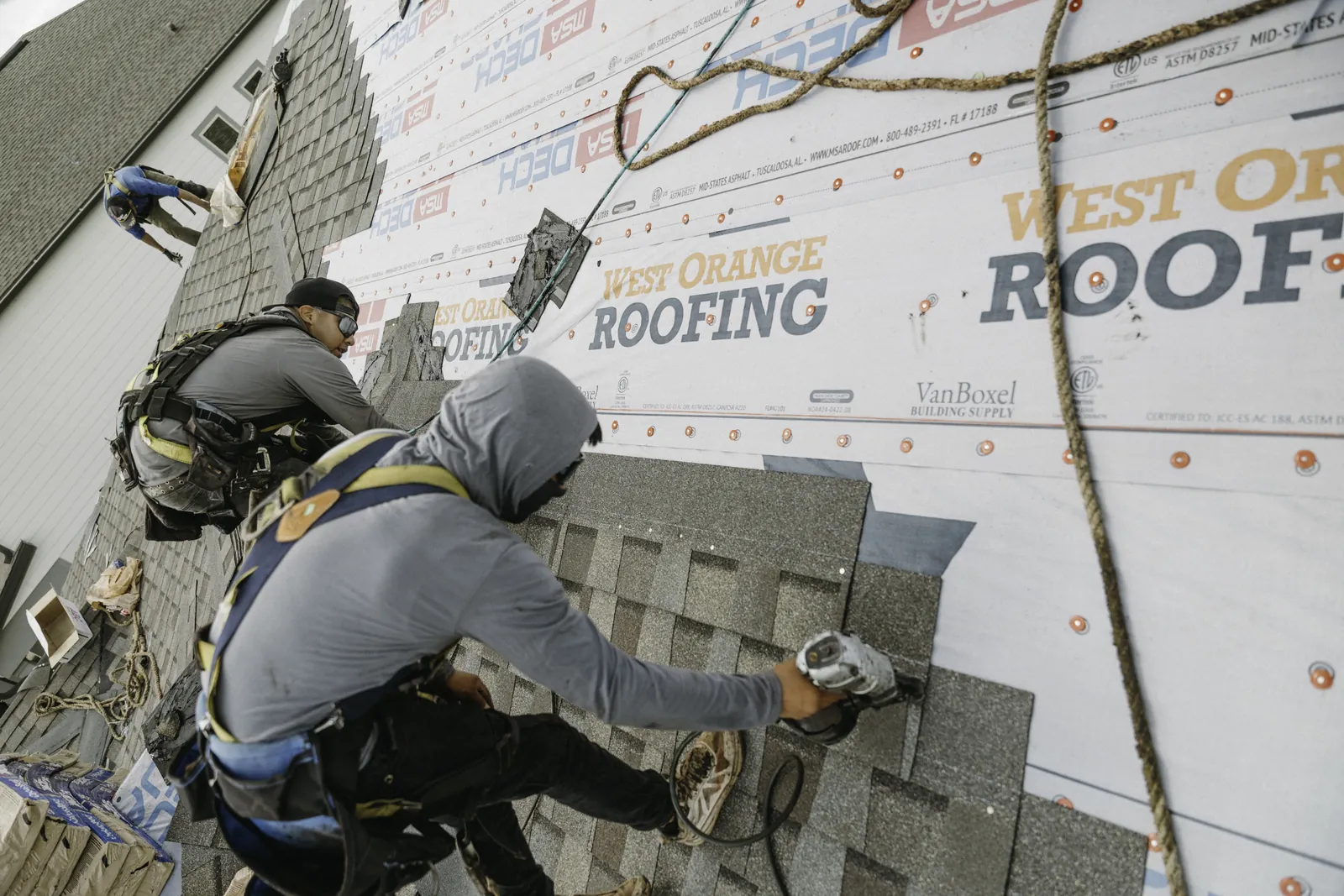 Roofer aligning an architectural shingle course