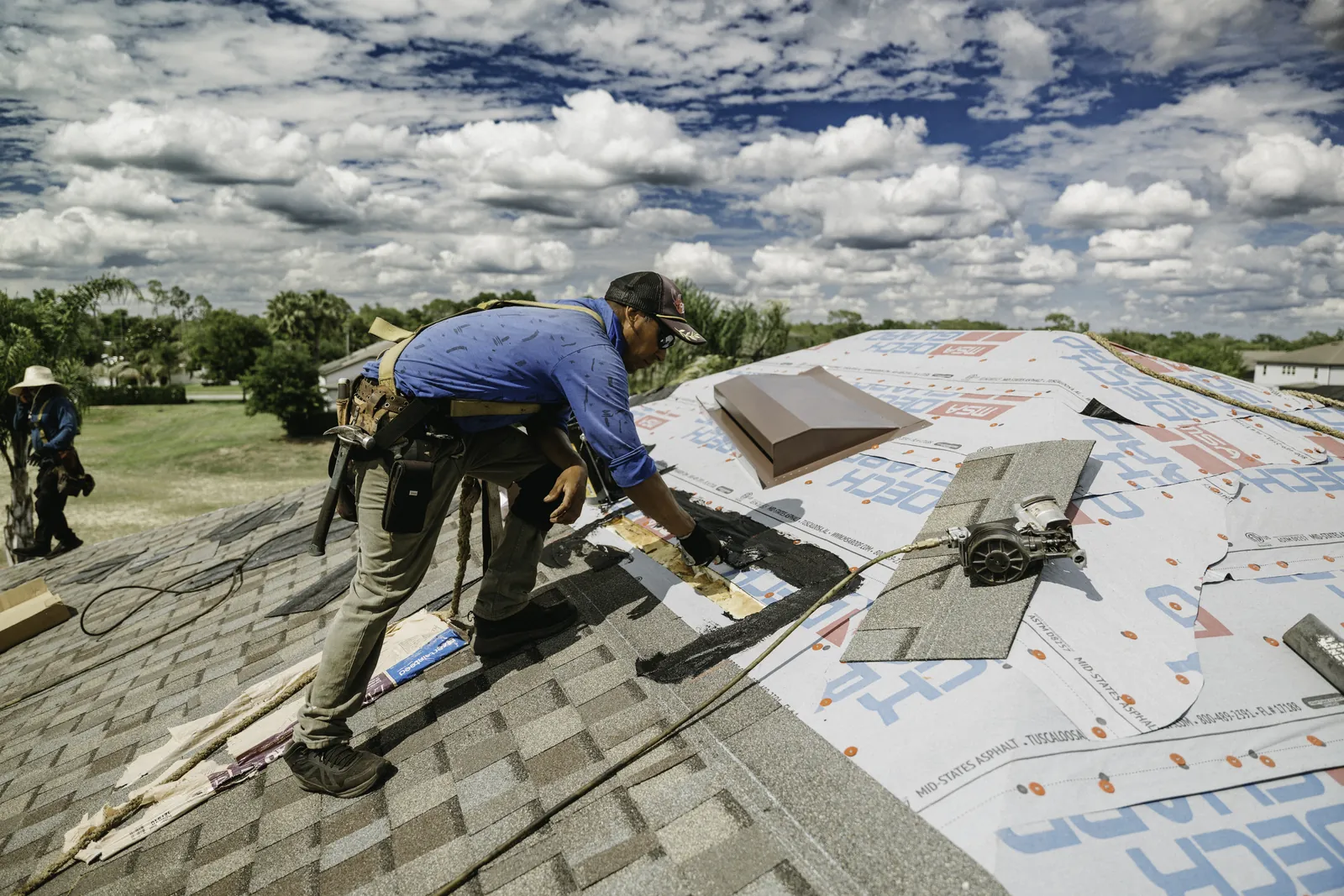 Roofer making a focused repair with roof sealant