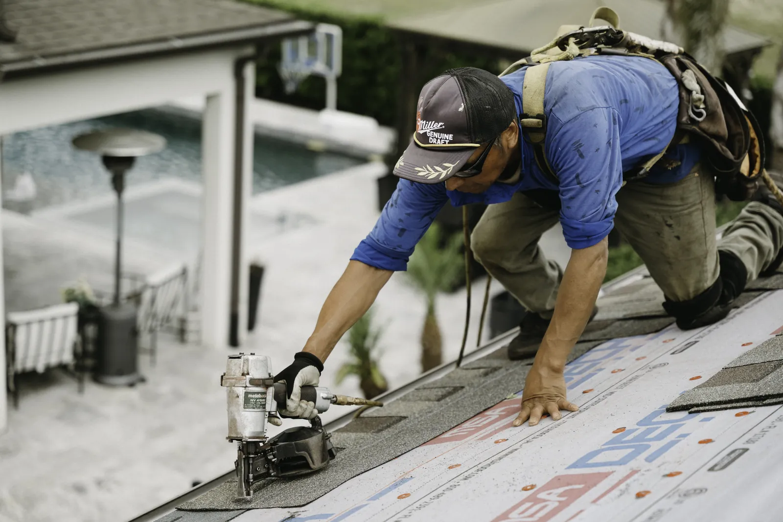 Roofer fastening materials at a roof edge