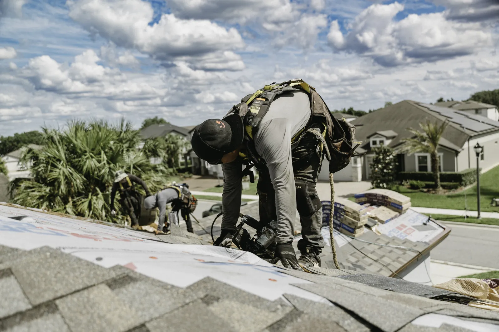 Close view of a roofer fastening shingles