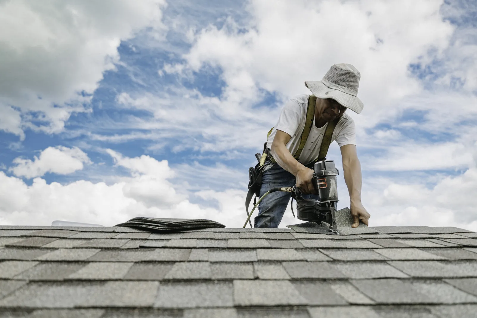 Roofer inspecting shingles and roofline details