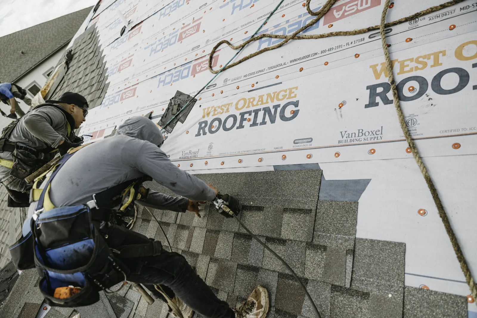 Roofer laying shingles in neat overlapping courses