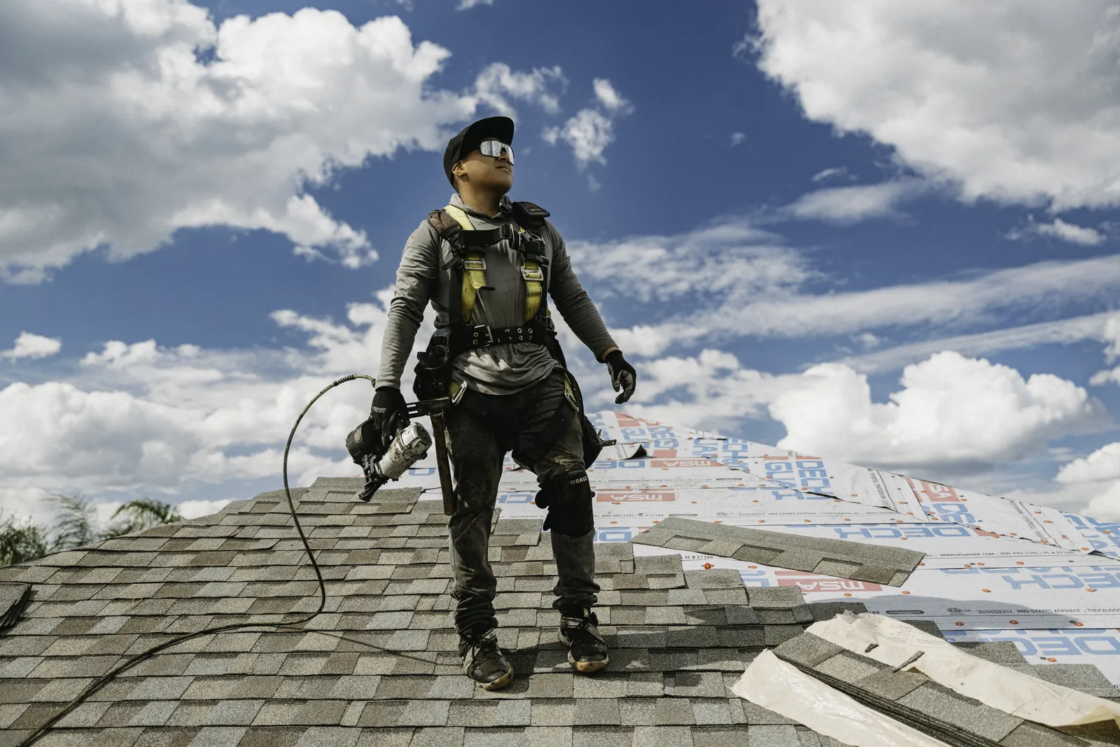 Roofing professional on a completed shingle roof during a quality review