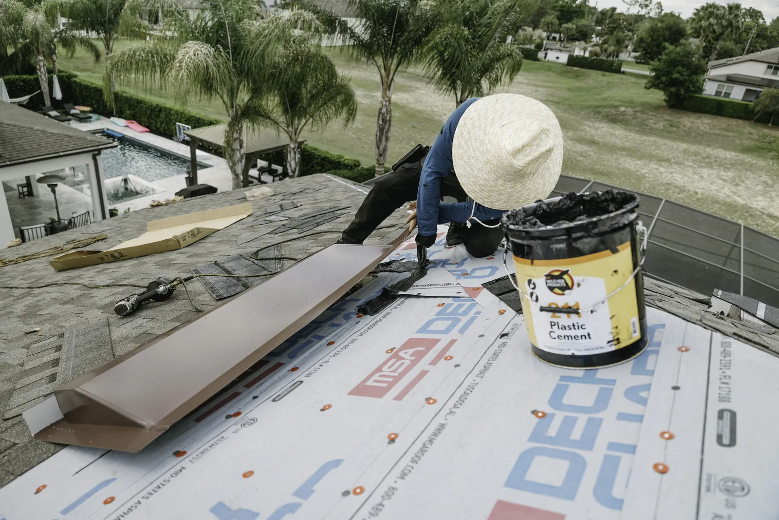 Roofer sealing a metal-roof vent penetration