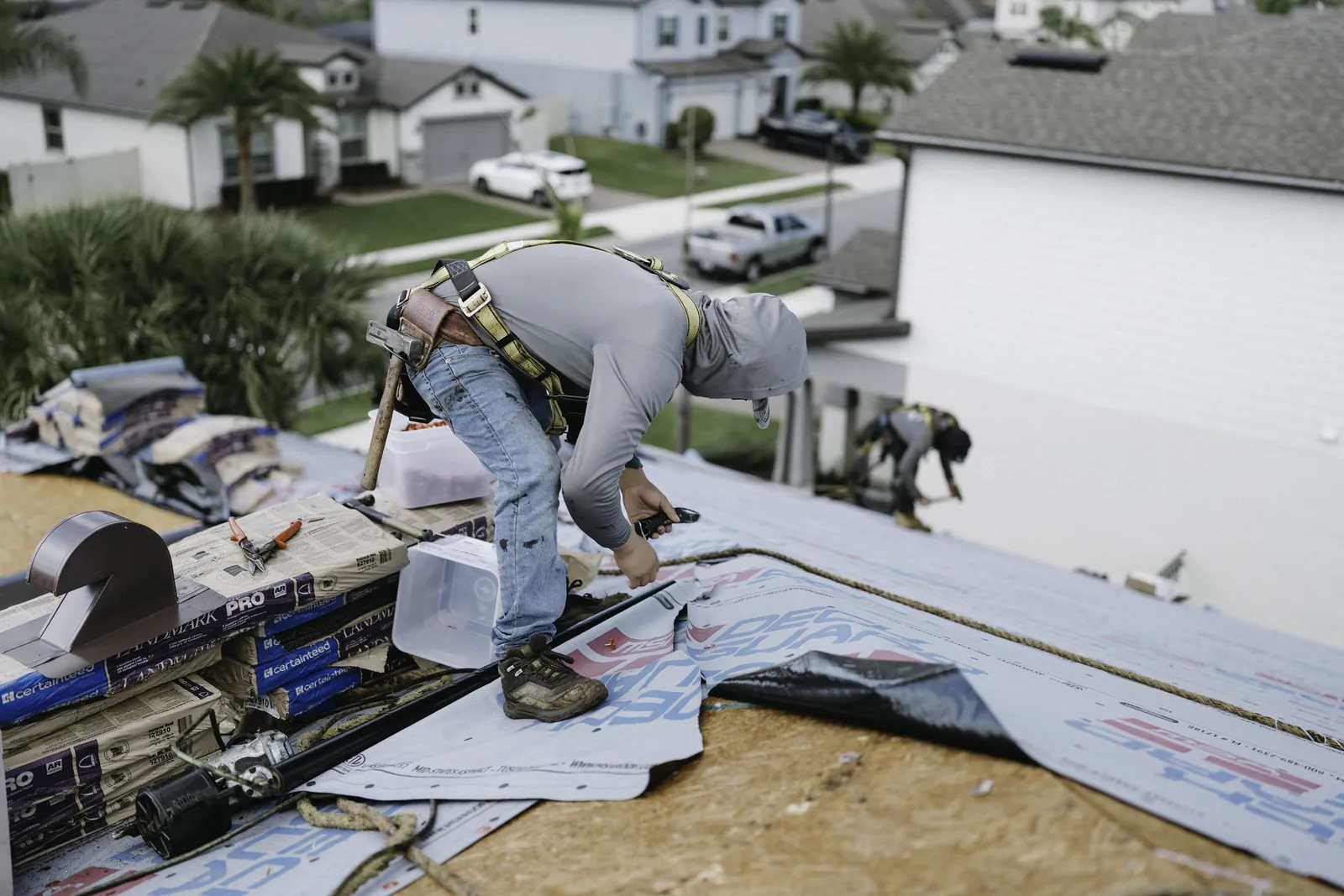 Roofer staging shingles for a residential roof installation