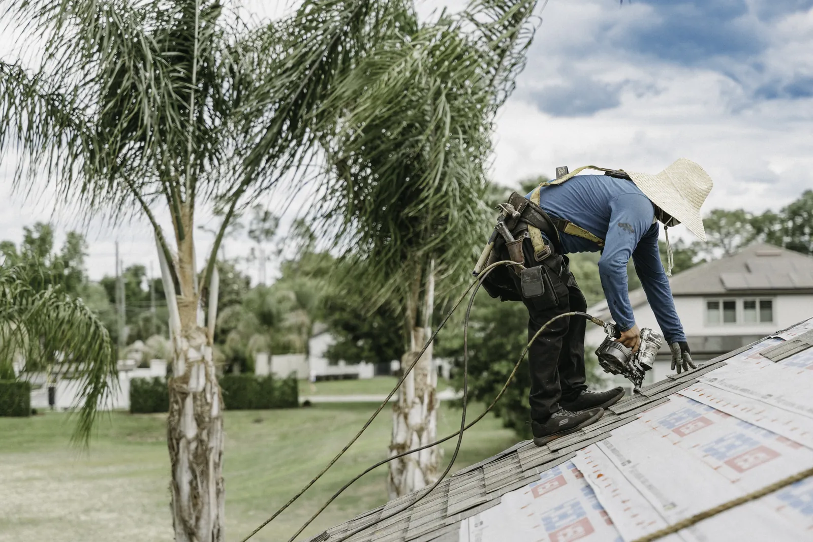 Roofers working along the eave of a residential roof