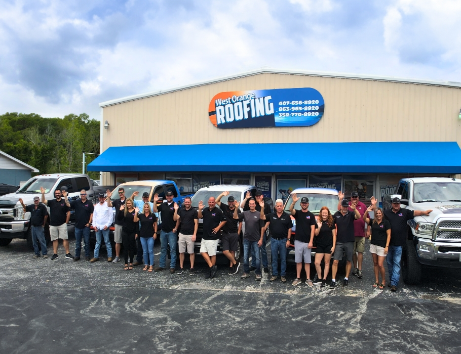 The West Orange Roofing team standing in front of the office waving at the camera